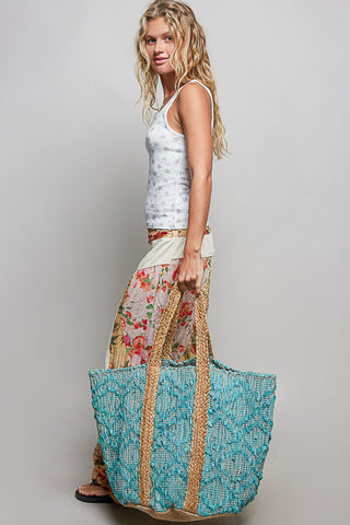 A spacious turquoise woven beach tote featuring chunky braided handles and a natural woven base—the perfect boho-inspired bag for beach days, poolside lounging, and tropical getaways.