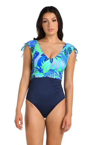 Vibrant tropical print in aquamarine, periwinkle, and teal with tropical leaf motifs
Plunging V‑neckline, shirred around bust and waist for a flattering silhouette
Color‑blocked design: printed top half paired with solid midnight/navy bottom
Tummy control and removable cups for comfort and coverage
Adjustable tie‑shoulder straps
Made of 85% Nylon, 15% Elastane 
